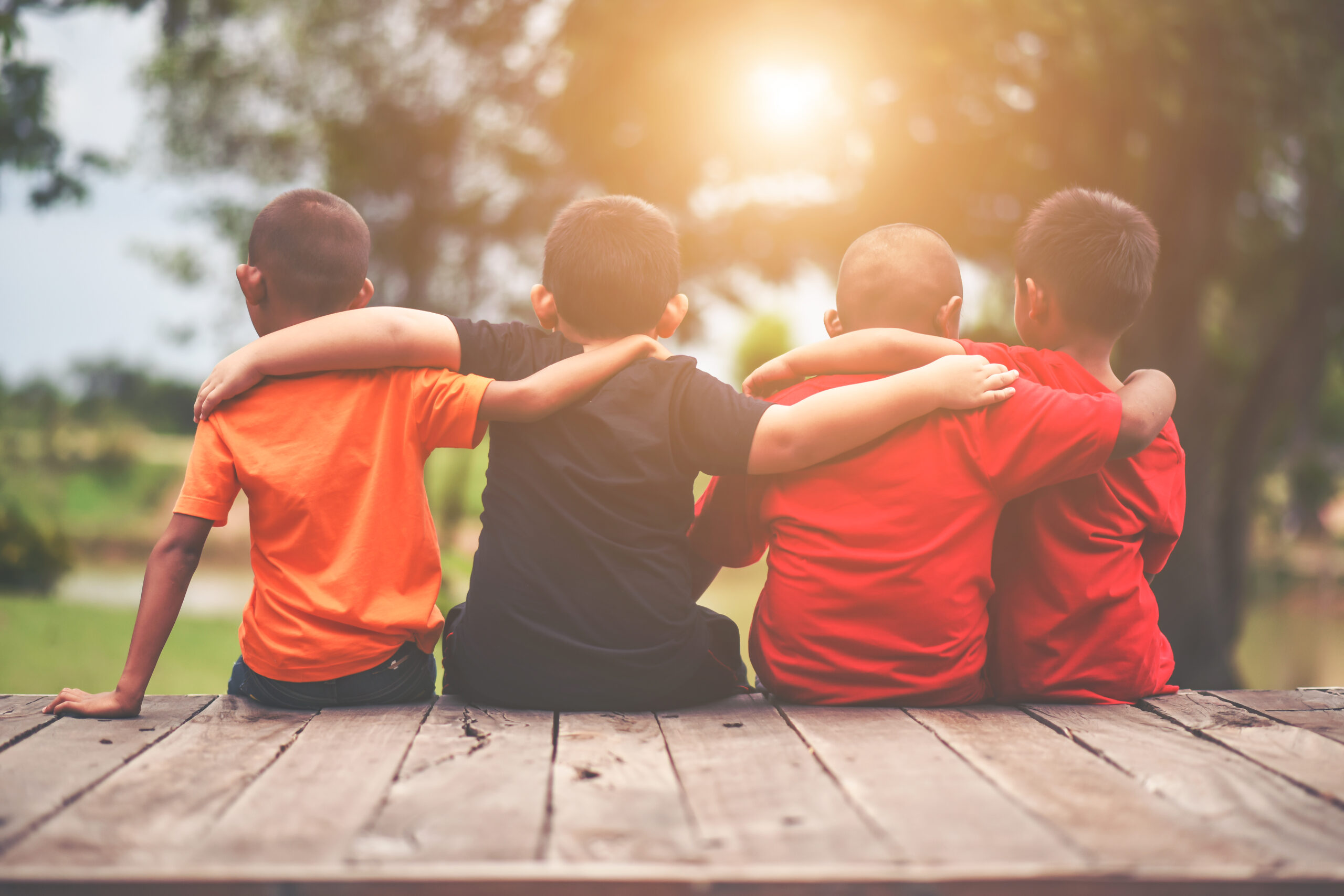 Group of kids friends arm around sitting together